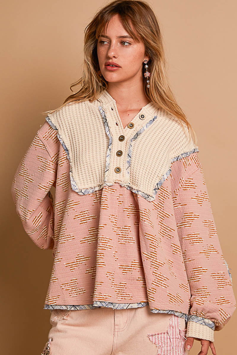 a woman wearing a pink and white sweater