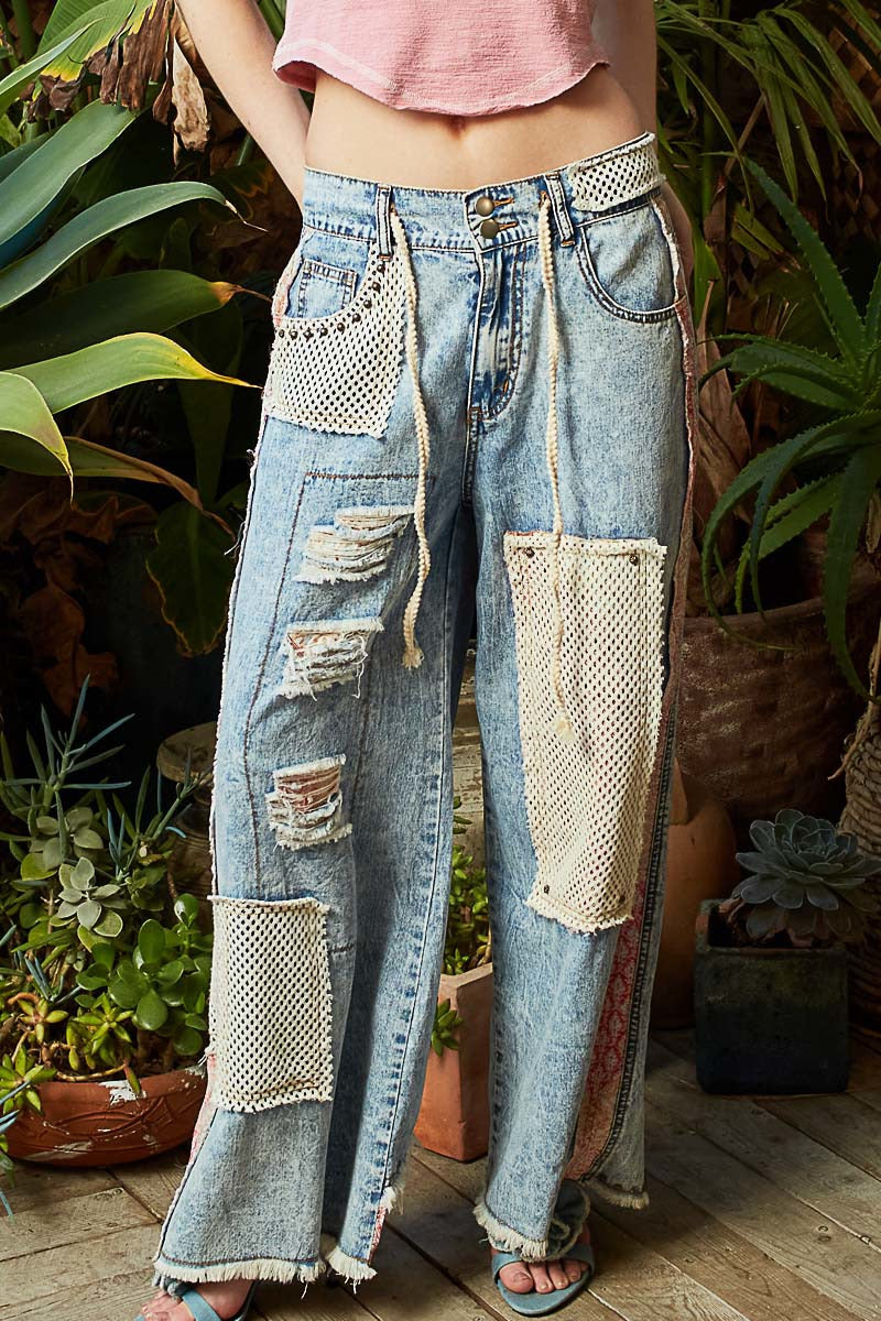 Person wearing patchwork jeans standing in a garden setting