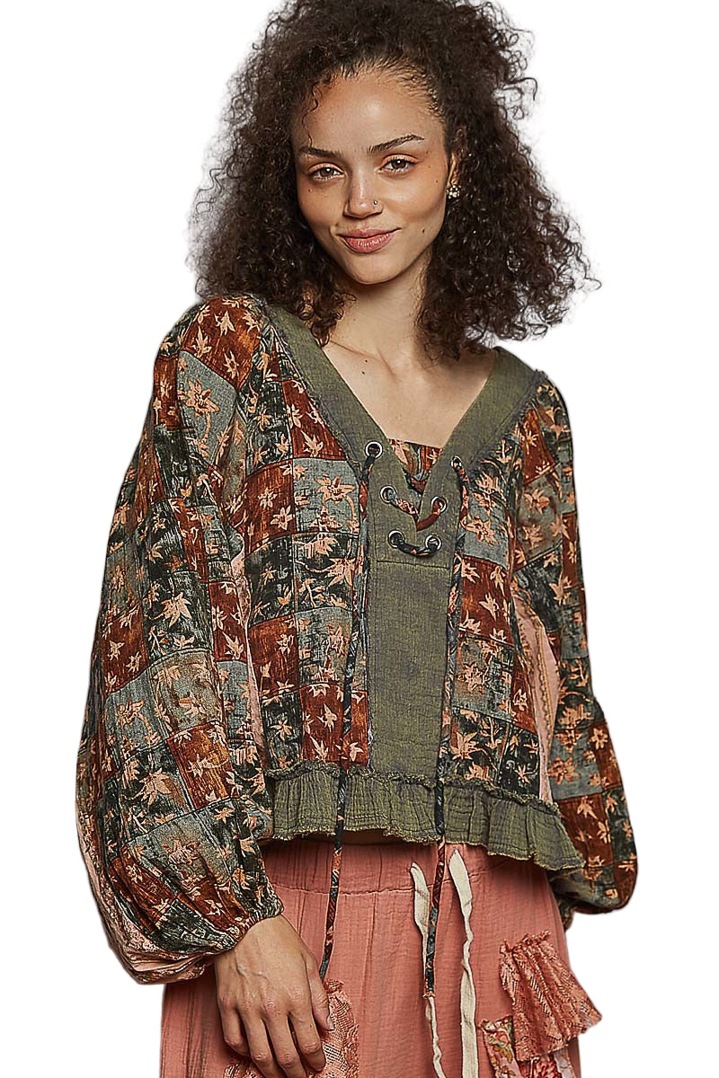 Woman wearing a patterned top with a plain background