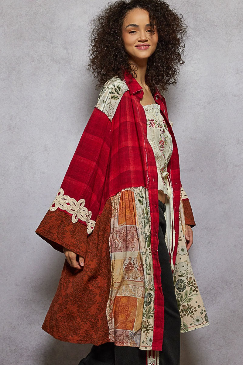 Woman wearing a colorful patchwork coat against a gray background