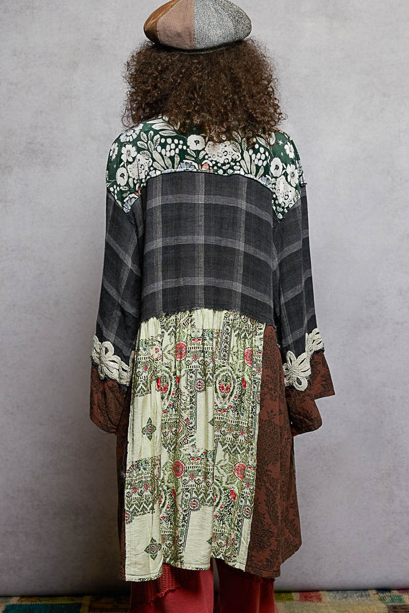 Person wearing a patterned coat with a gray background