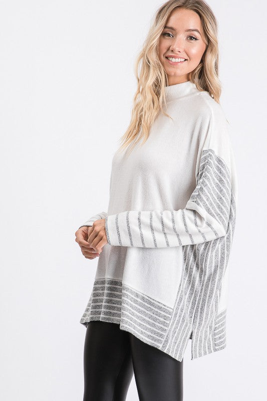 a woman wearing a white sweater and black leggings