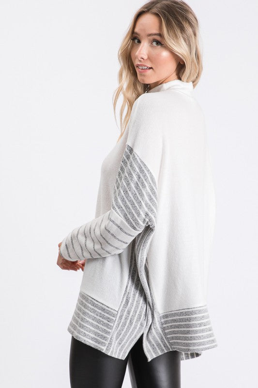 a woman wearing a white sweater and black leggings