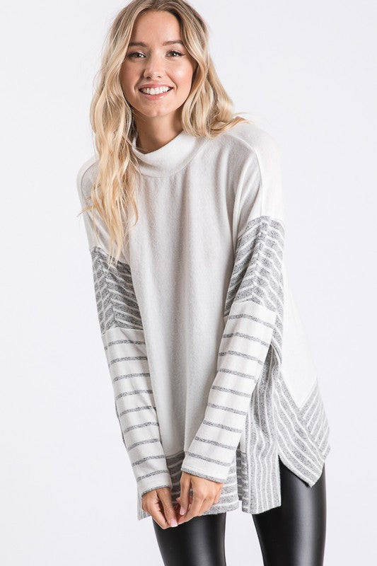 a woman wearing a white sweater and black leggings