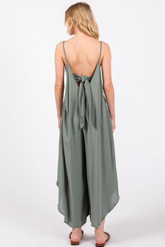 a woman wearing a green jumpsuit with a back tie