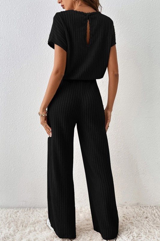 a woman wearing a black jumpsuit with open back