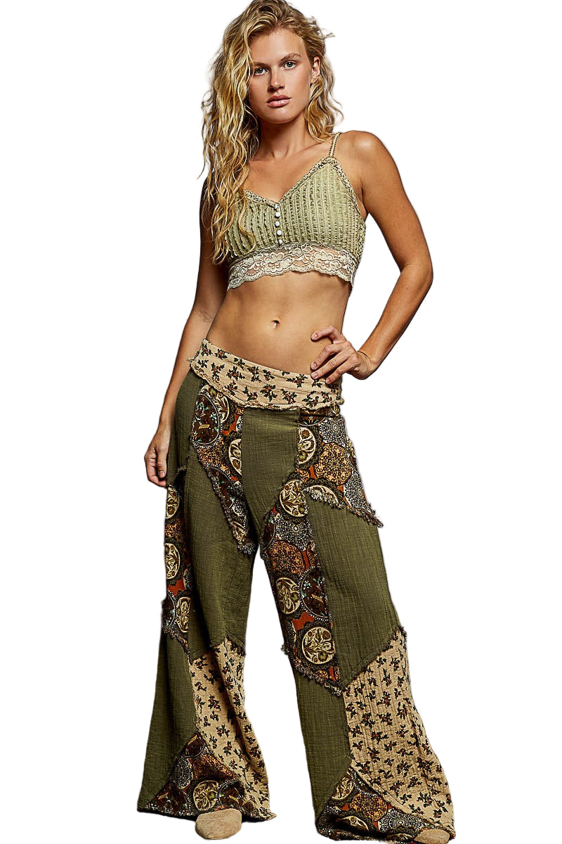 Woman wearing a green patterned outfit against a gray wall.