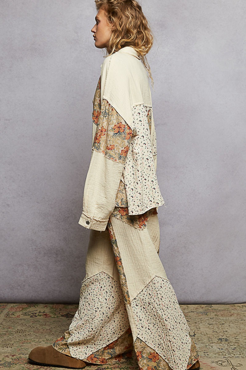 Person wearing a floral and lace patterned outfit against a plain background