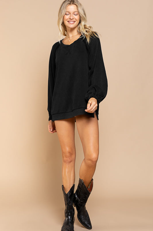 a woman wearing a black sweater and cowboy boots