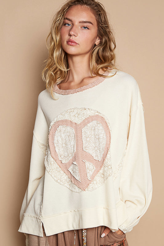 a woman wearing a sweater with a peace sign on it