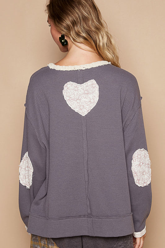 a woman wearing a sweater with a heart on it