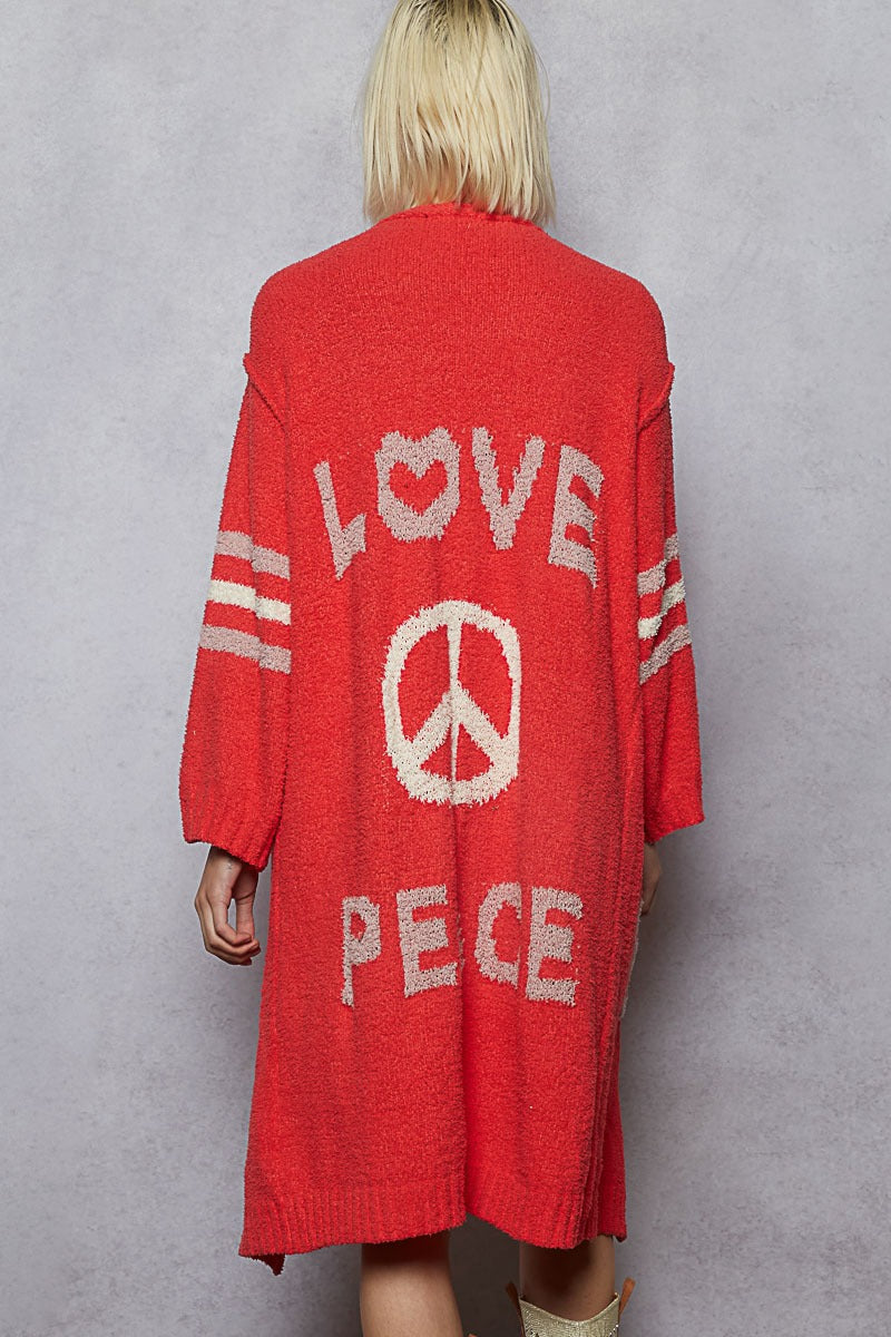 Red cardigan with 'LOVE PEACE' text and peace symbol on a gray background