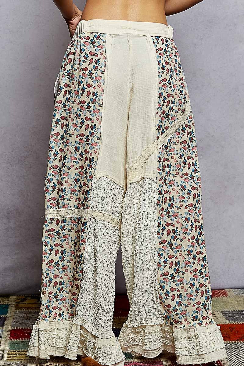 Floral print pants with ruffled bottom on a plain background