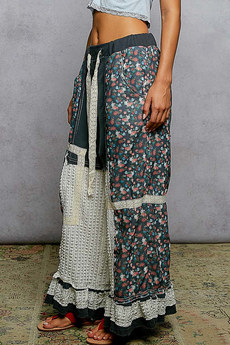Long floral skirt with a textured pattern worn by a person against a gray wall.