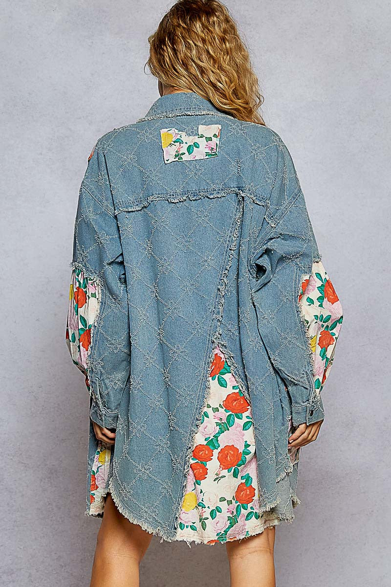 Denim jacket with floral patchwork design on a plain background