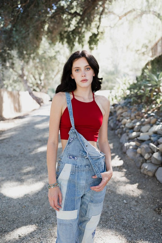 a woman wearing overalls and a red top