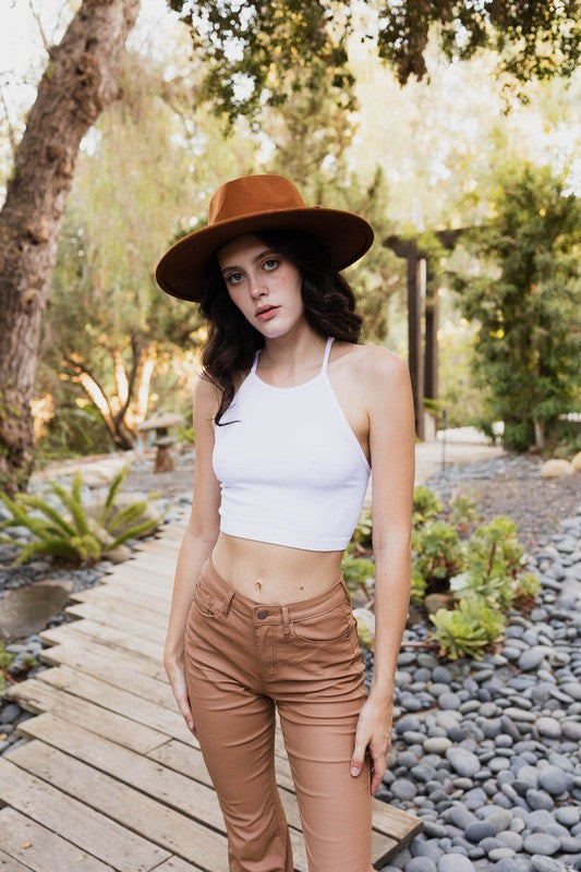a woman wearing a brown hat and tan pants