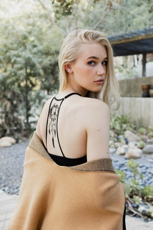 a woman with blonde hair wearing a tan sweater