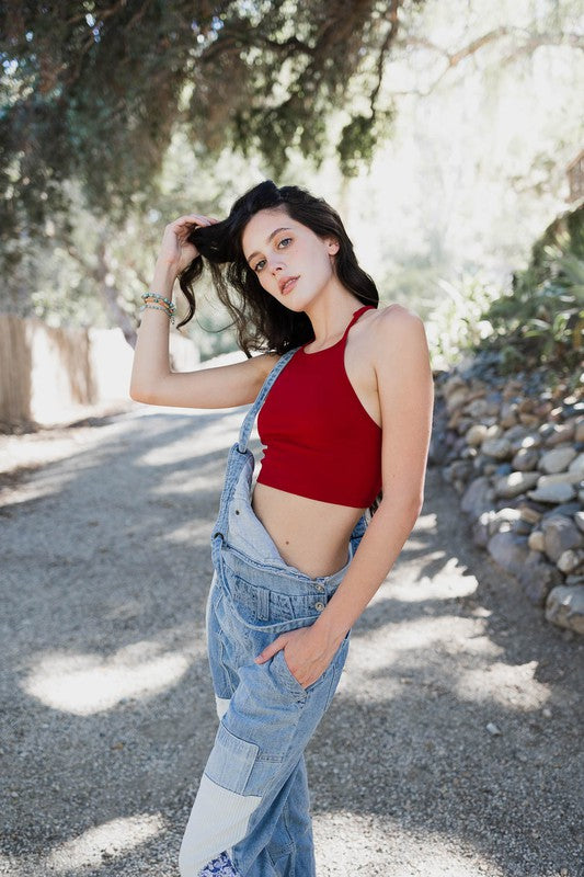 a woman in a red top and overalls posing for a picture