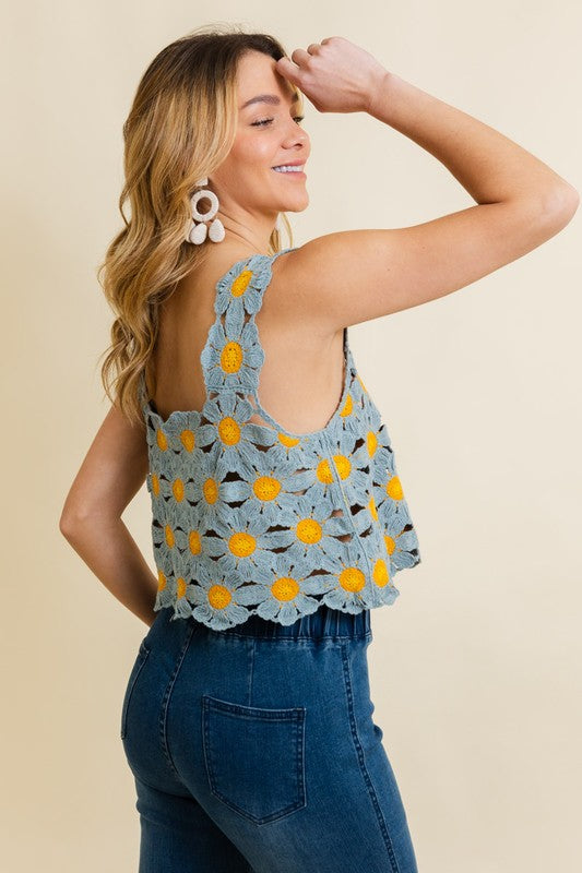 a woman wearing a crochet top and jeans