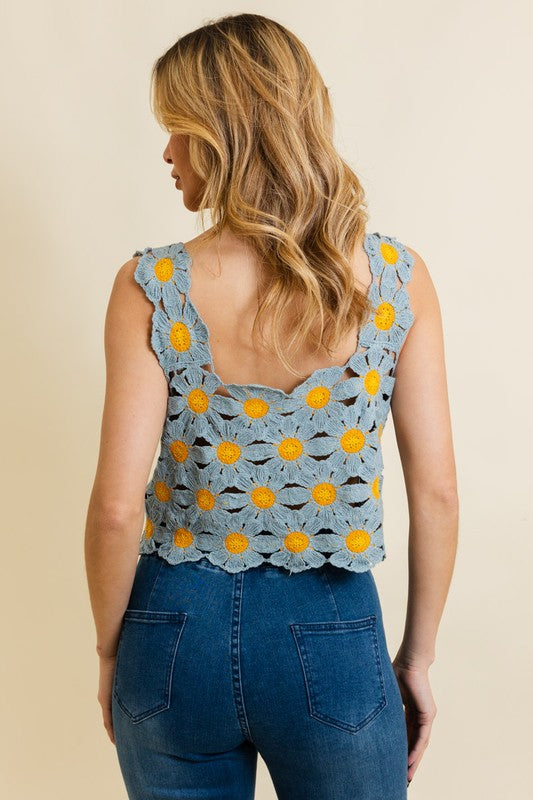 a woman wearing a blue top with yellow flowers on it