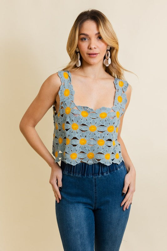 a woman wearing a blue top with yellow flowers on it