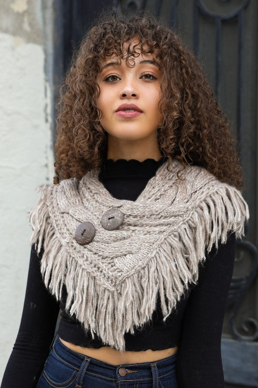 a woman with curly hair wearing a knitted scarf