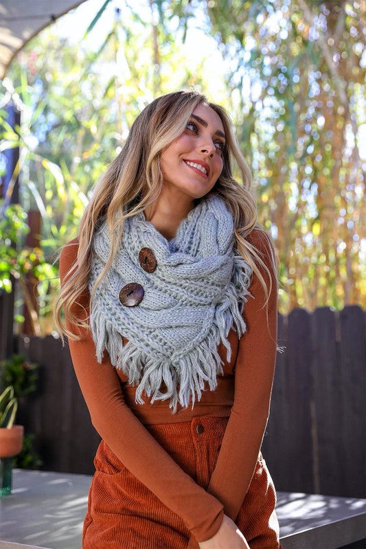 a woman wearing a scarf with buttons on it