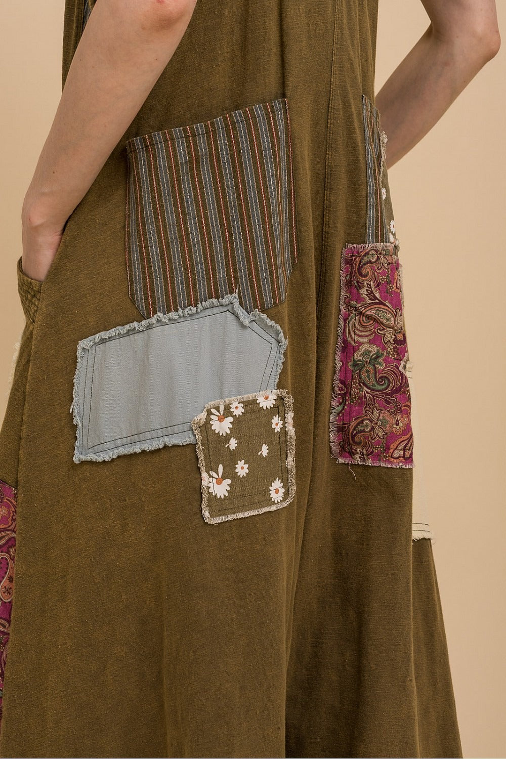Brown dress with patchwork pockets on a beige background