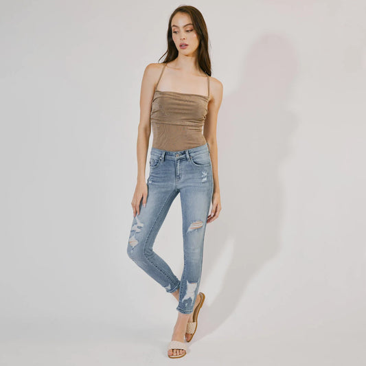 Medium stone washed smooth body-hugging fit ankle skinny featuring light fading, whiskering, and subtle tattered and distressed details.