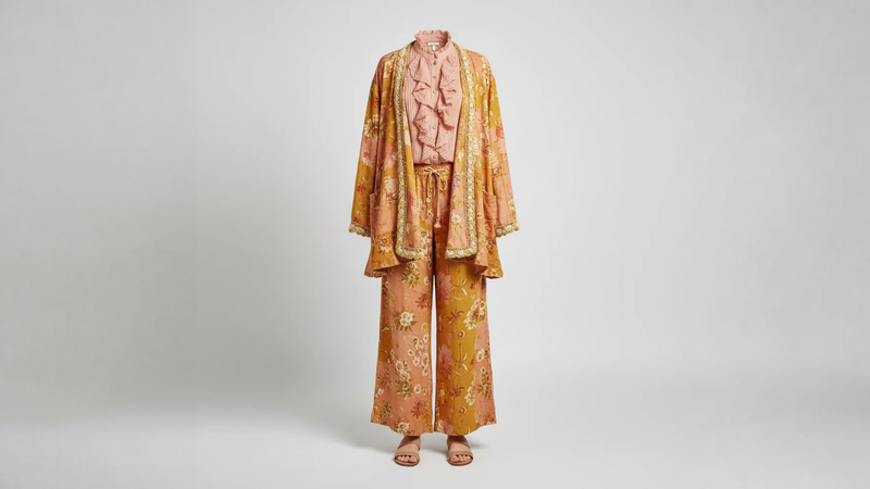 A Rare Bird Shop boho-luxe collection — ghost mannequin outfit with patchwork jacket, eyelet blouse, palazzo pants, and tan sandals