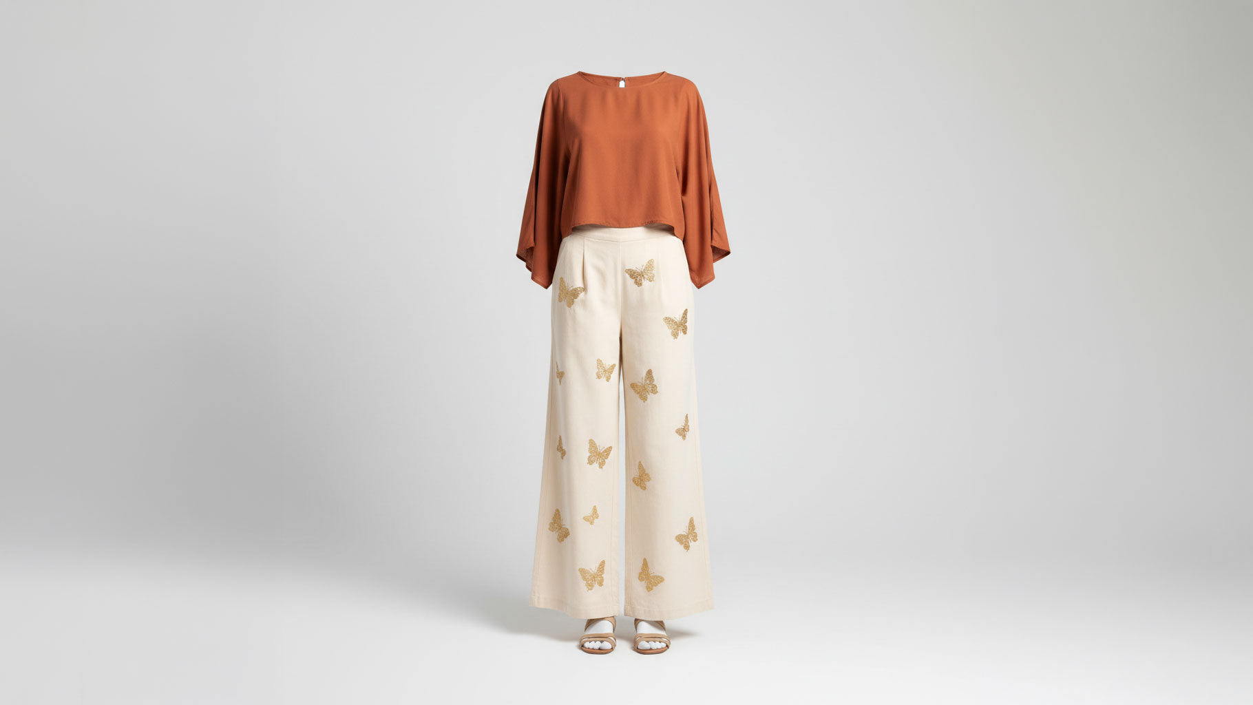 Women's wide-leg boho trousers with butterfly embroidery styled with terracotta blouse, ghost mannequin studio shot - BellanBlue
