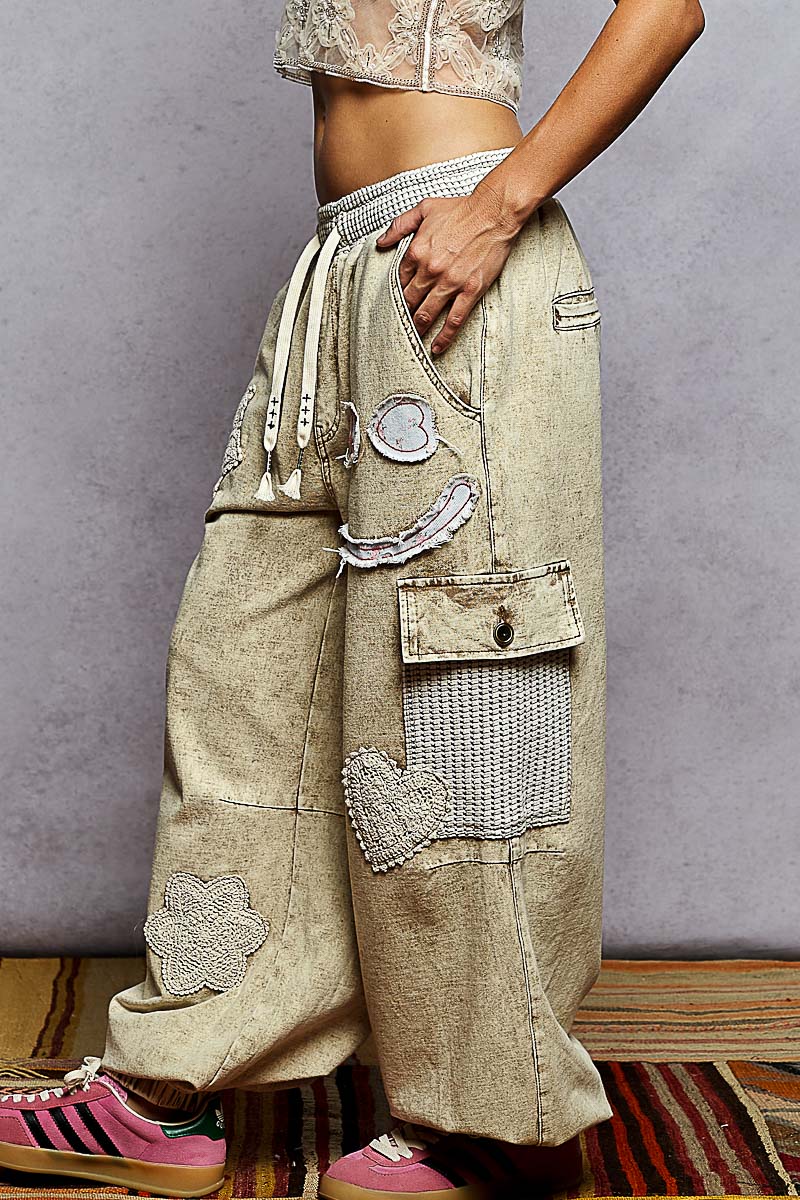 Person wearing patchwork pants with a plain background