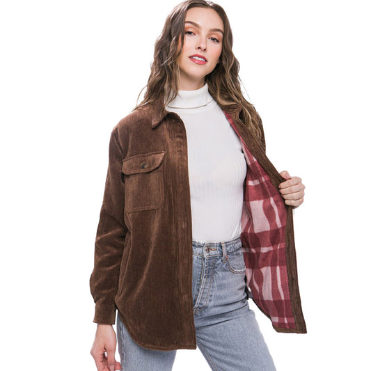 a woman wearing a brown jacket and plaid scarf