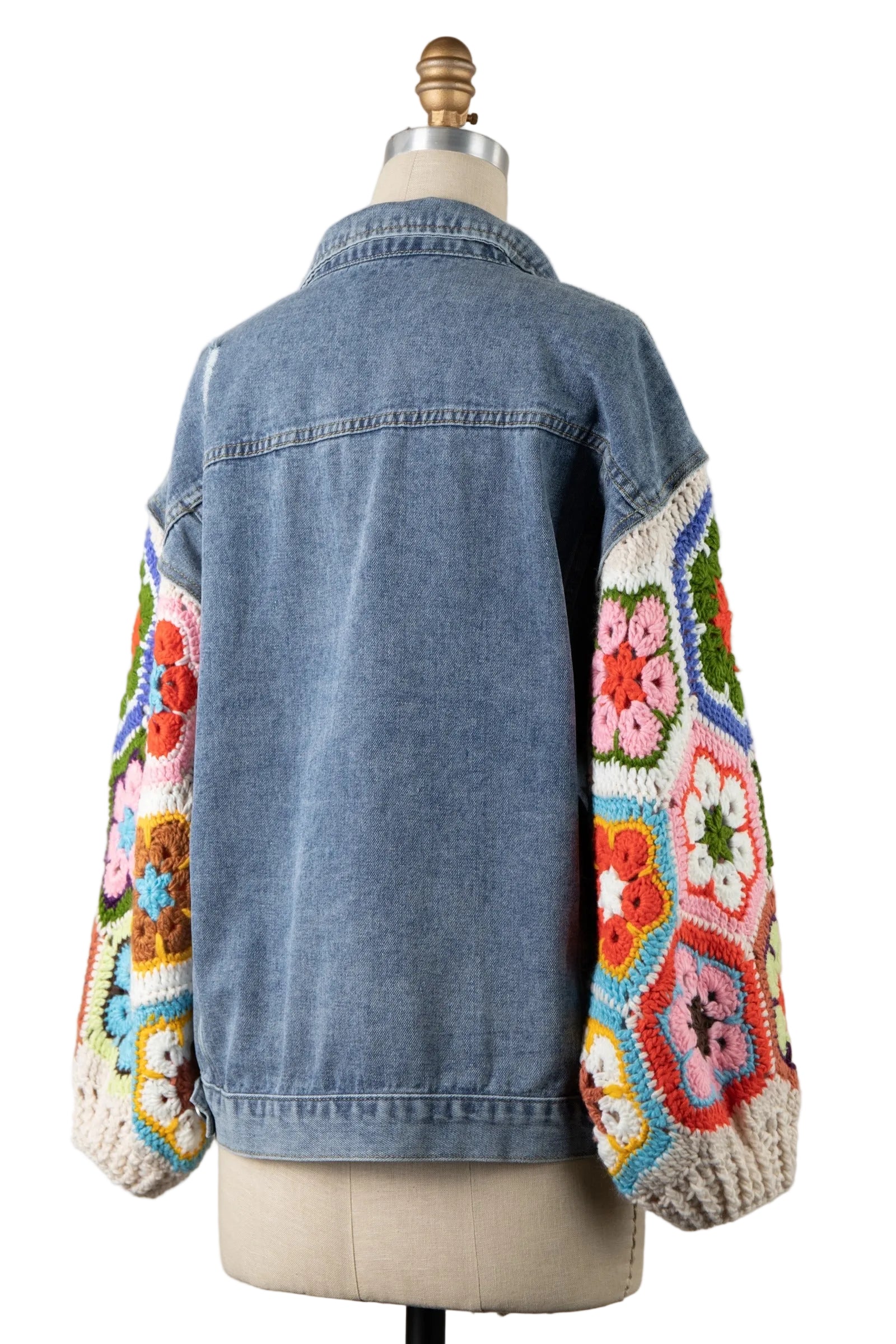 Women's denim jacket back view showing uniform blue wash panel and full colorful granny square crochet sleeves