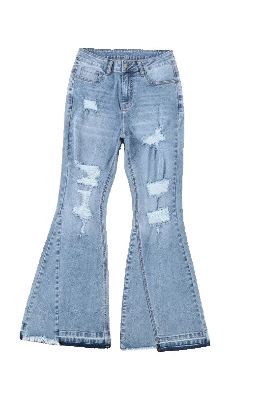 Distressed blue jeans on a white background with sunglasses and a magazine.