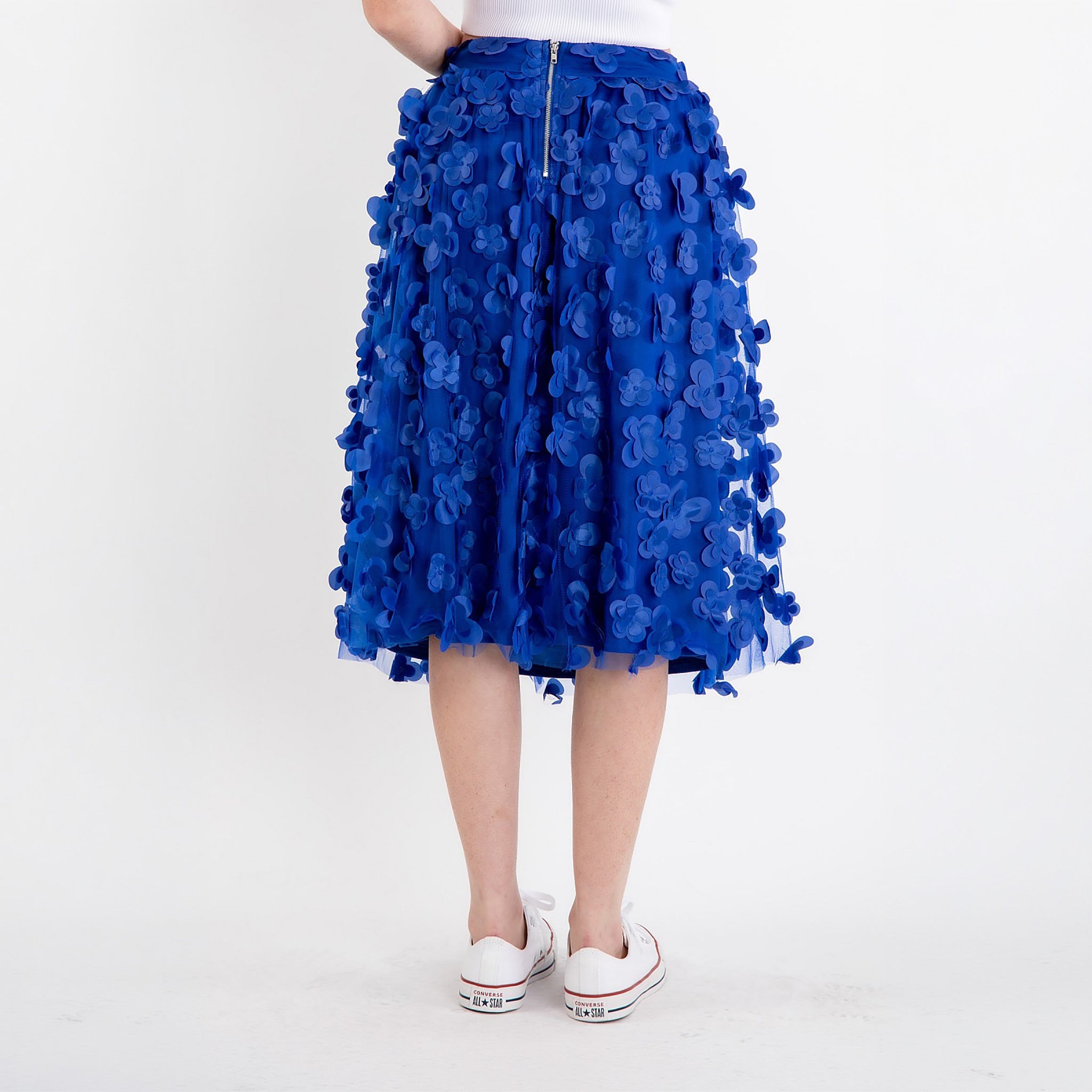 Close-up of floral appliqué detail on women's royal blue mesh midi skirt sheer overlay fabric