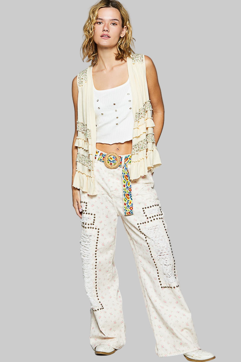 Woman wearing a white outfit with decorative elements on a gray background