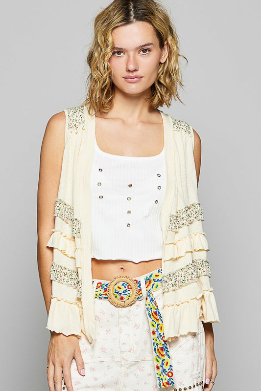 Woman wearing a white top and skirt with a decorative belt against a gray background