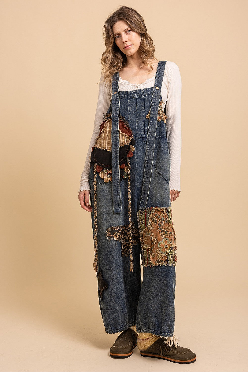 Bluevelvet denim patchwork overalls on model, three-quarter front view showing bib hardware and patchwork detail
