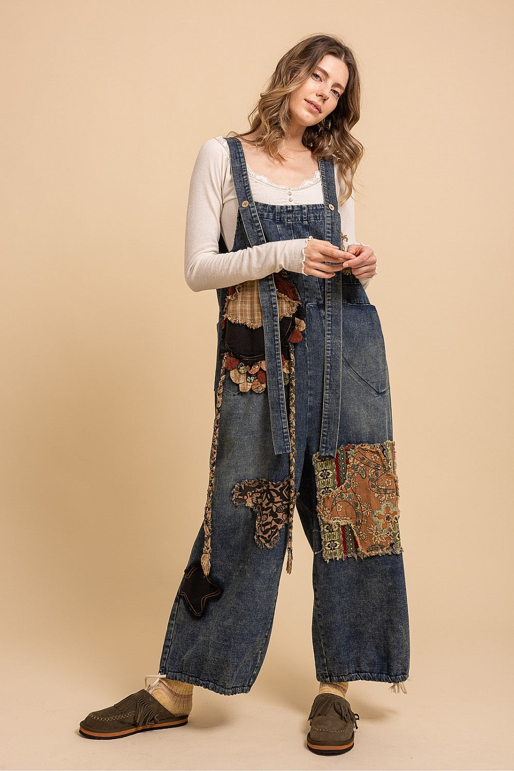 Bluevelvet denim patchwork overalls on model, close-up three-quarter view showing bib, straps, and upper patchwork
