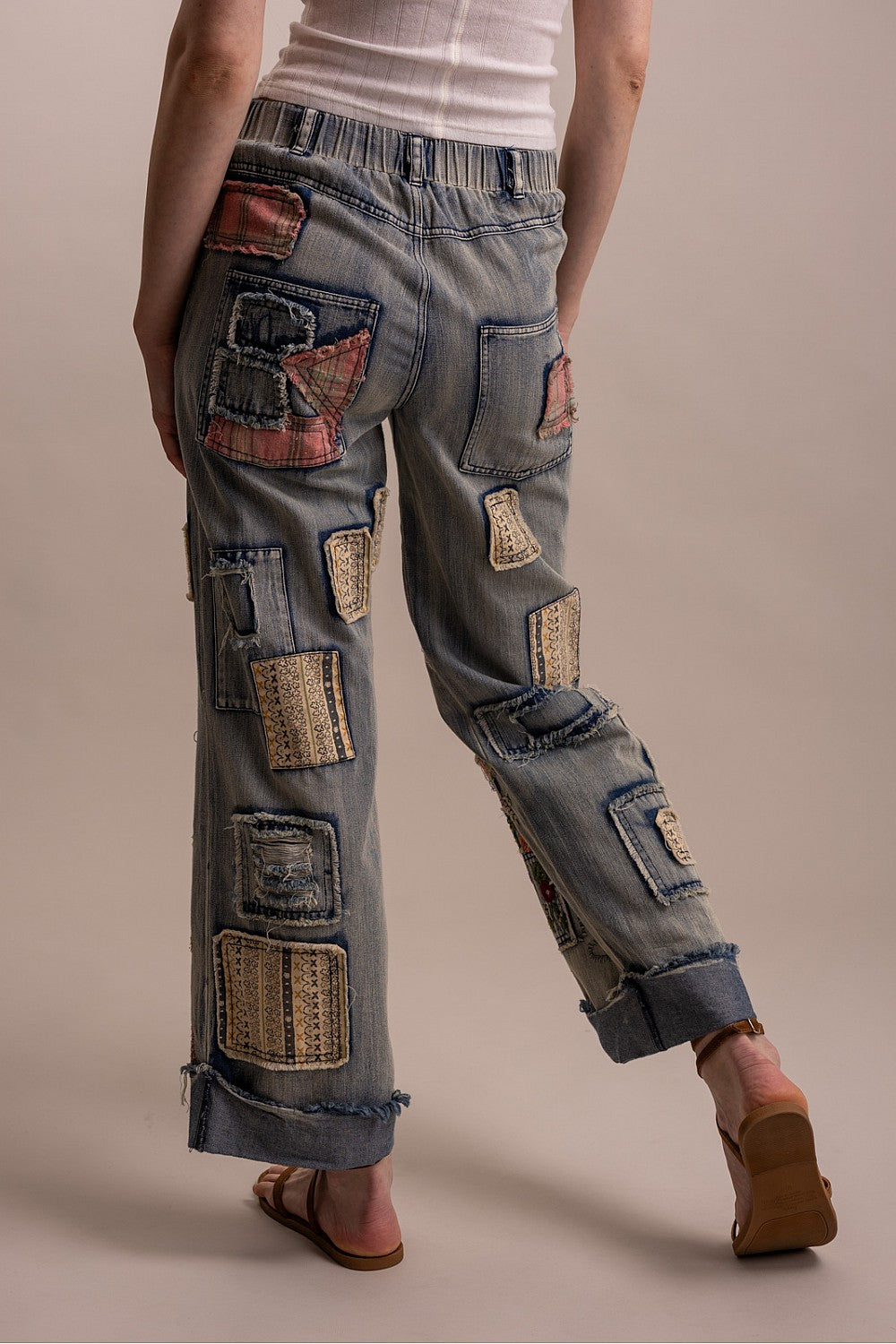 Blue Velvet patchwork embroidered wide-leg denim pants, back view on model showing mixed-fabric patches and cuffed hem
