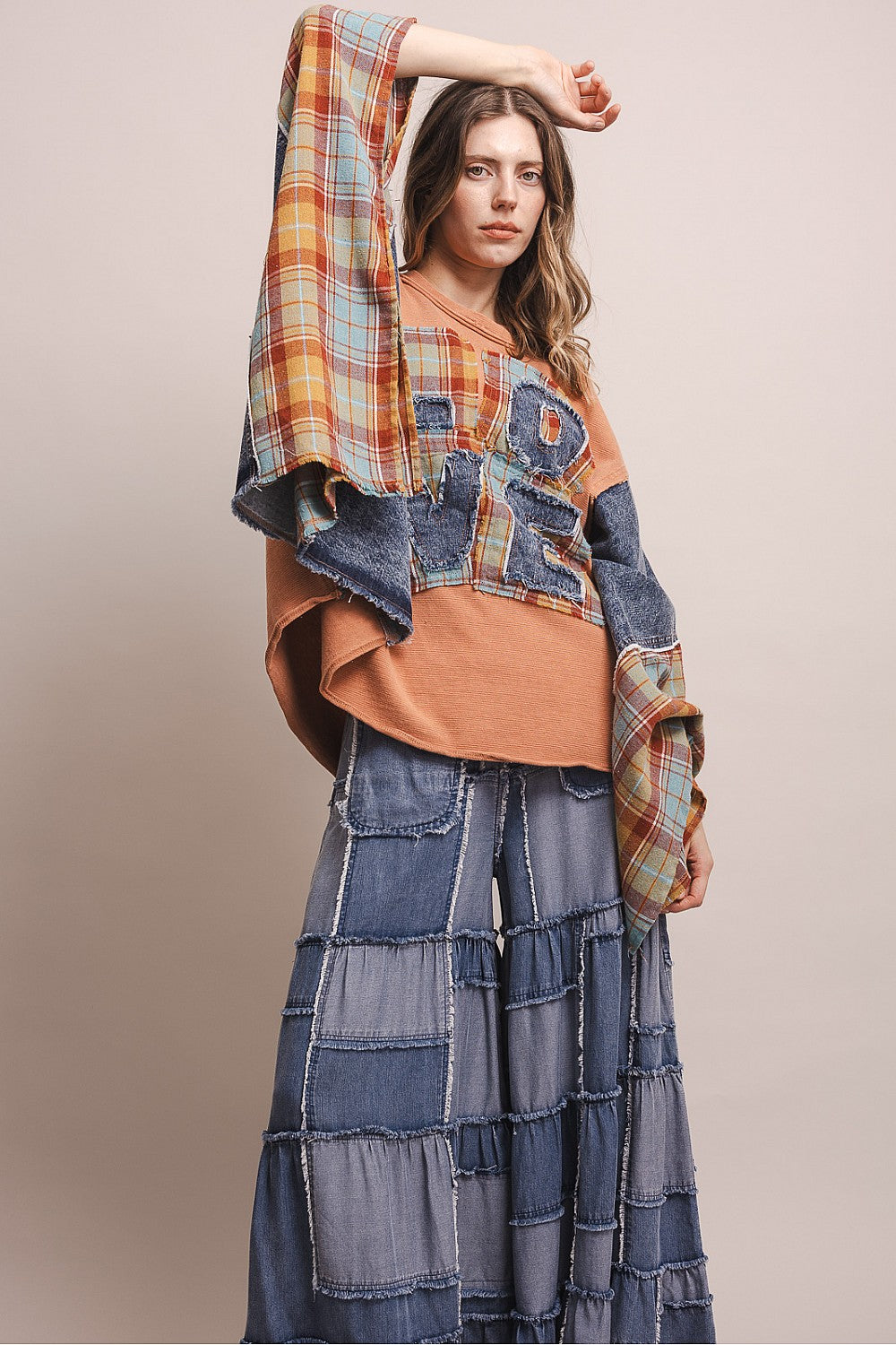 Bluevelvet coral poncho top with LOVE patchwork lettering, full-length front view on model with tiered denim skirt
