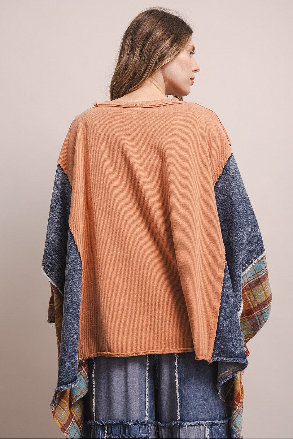 Bluevelvet coral patchwork poncho top with plaid sleeve detail, overhead arm pose showing sleeve width on model
