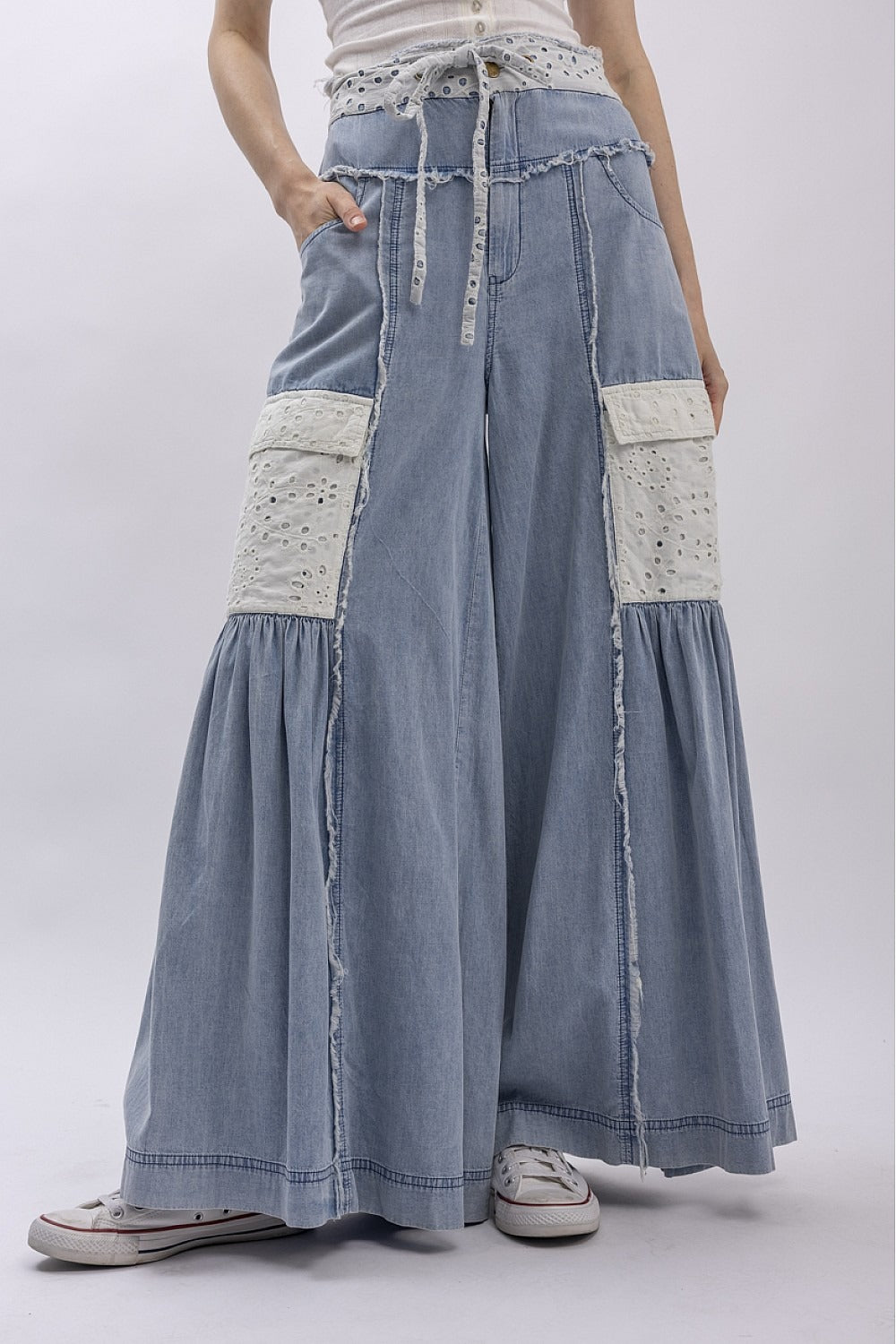 Long denim skirt with white patches on a plain background