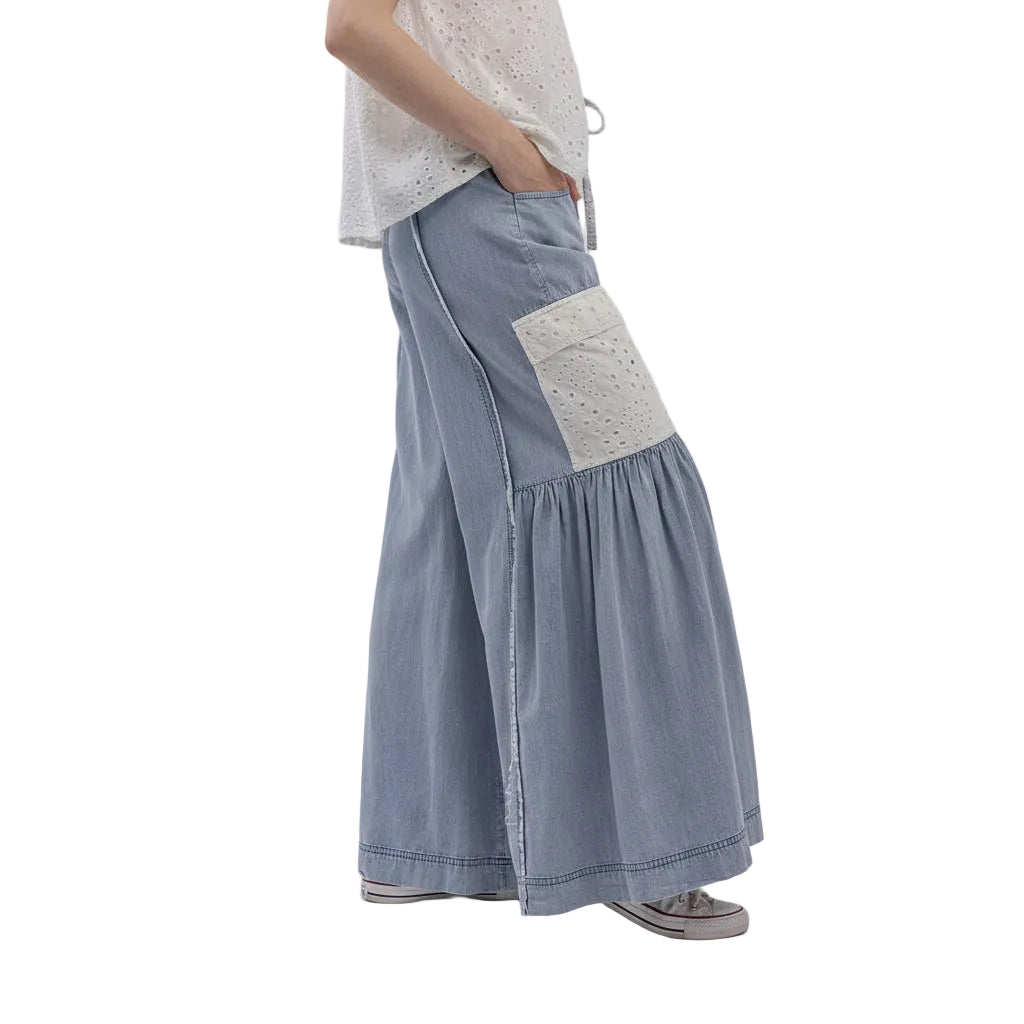 Light blue denim pants with a white patch on a white background