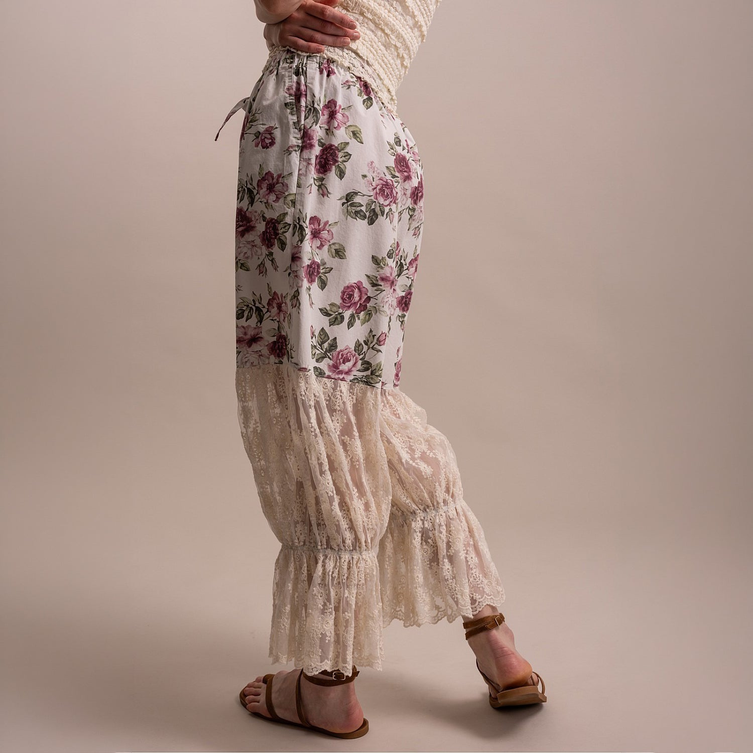 Bluevelvet women's off white floral pants, back-angle view showing drawstring waist tie and lace ruffle hem

