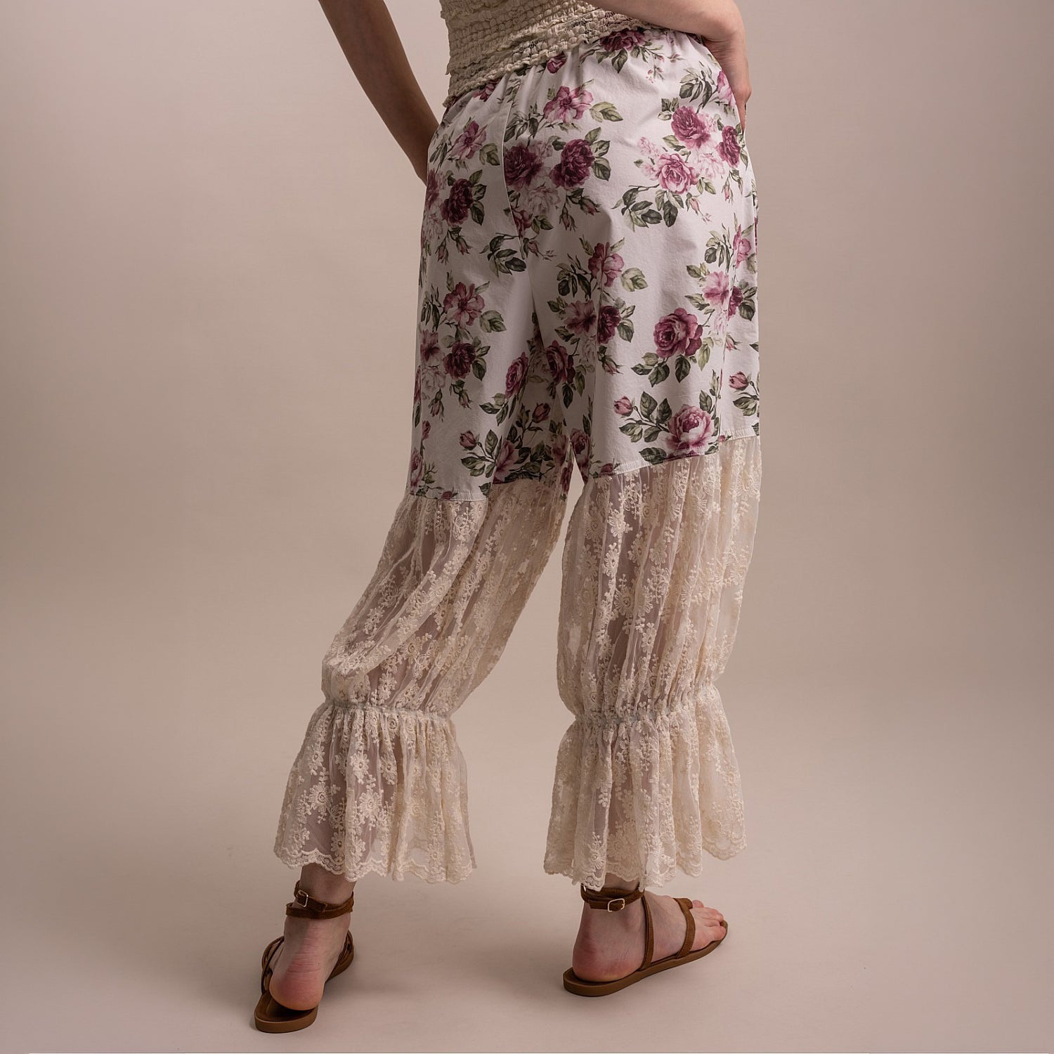 Bluevelvet women's off white floral lace ruffle cuff pants, side walking pose showing lace panel movement
