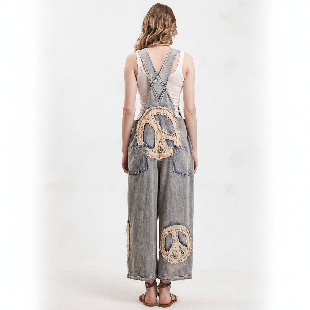 Person wearing Bluevelvet denim overalls with peace symbol patches on a white background
