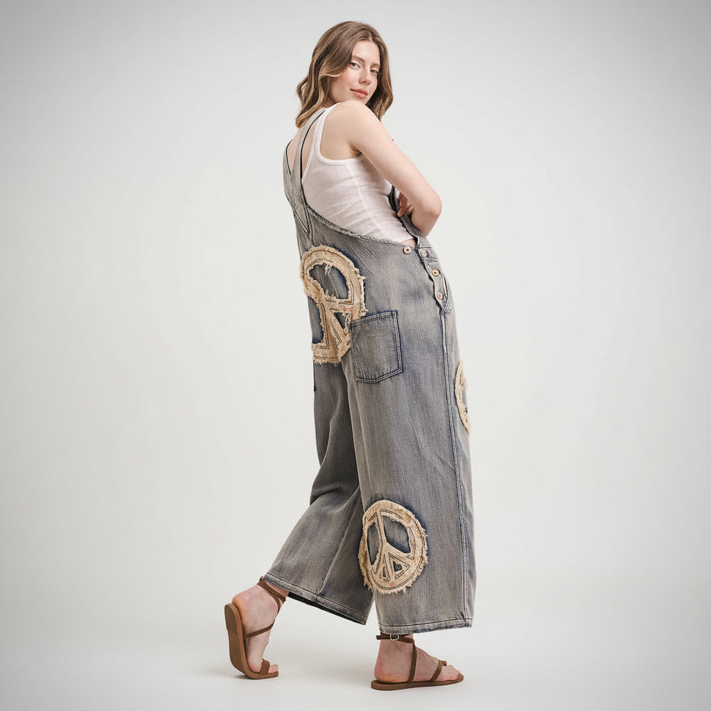 Woman wearing Bluevelvet denim overalls with peace symbol patches on a white background